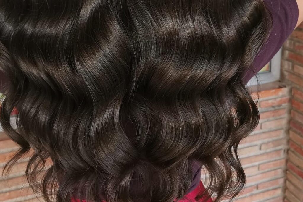 Detalle de una melena con ondas y brillo tras un tratamiento en Neyfa Estilistas